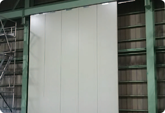 ertical installation of large white SN Panels forming a high-performance insulated wall inside an industrial warehouse with visible steel framing.