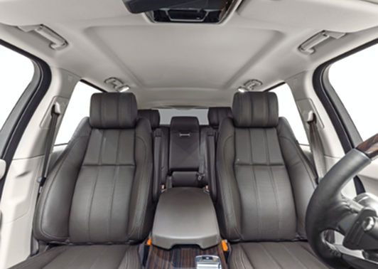 Interior view of a car looking forward at the leather front seats and console.