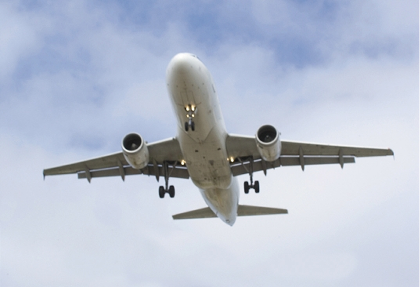 Underside view of an airplane taking off.